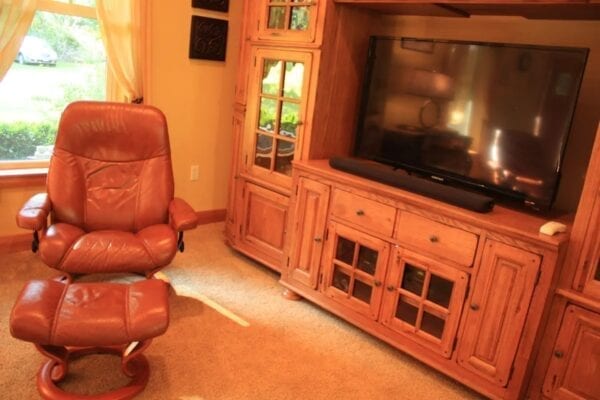 A living room with a large entertainment center and leather furniture.